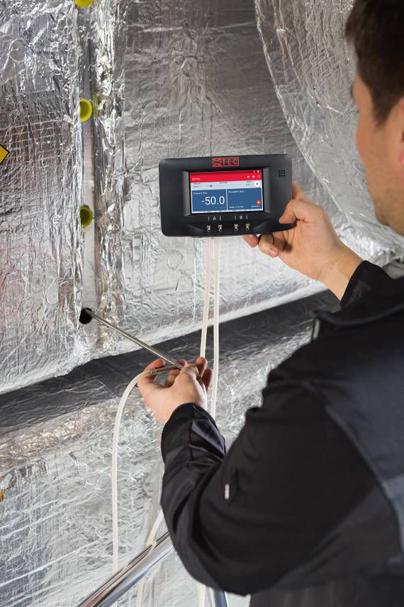 Manometer with tubing connected to HIGH and LOW ports, with labels showing which tube goes to supply vs return